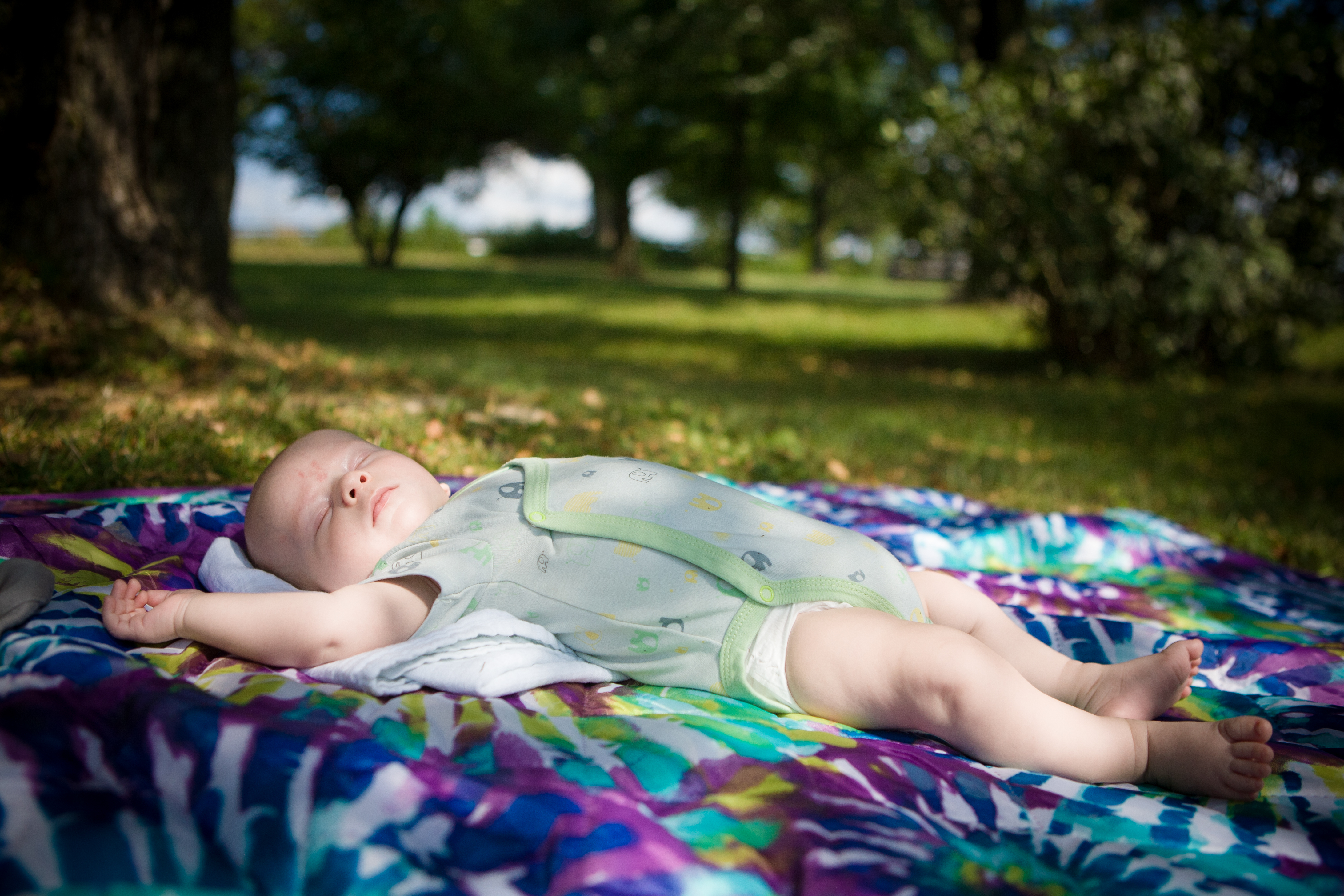 baby napping on blanket on grass